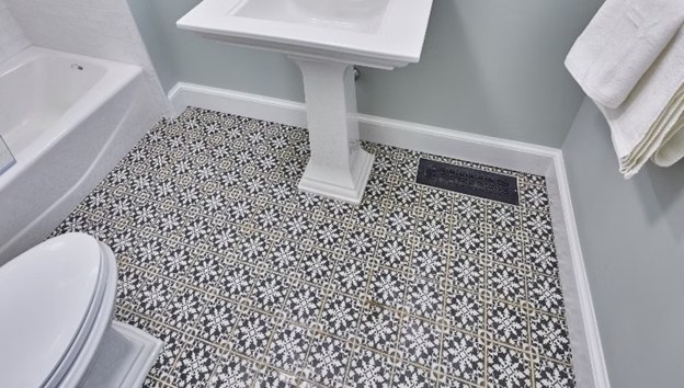 A patterned encaustic-style tile floor laid around a pedestal basin