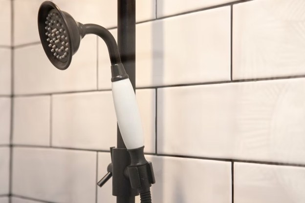 Handmade white subway tile photographed close up under a shower fitting
