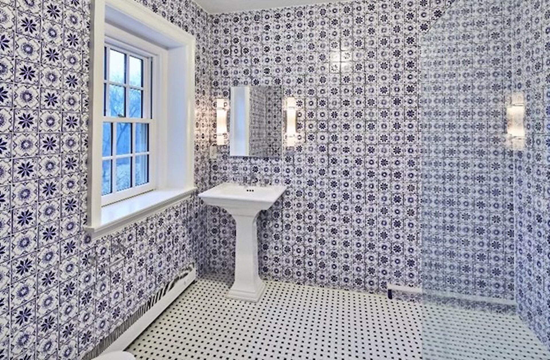 Emerald hexagon wall tile set against an exposed stone wall in a finished bathroom